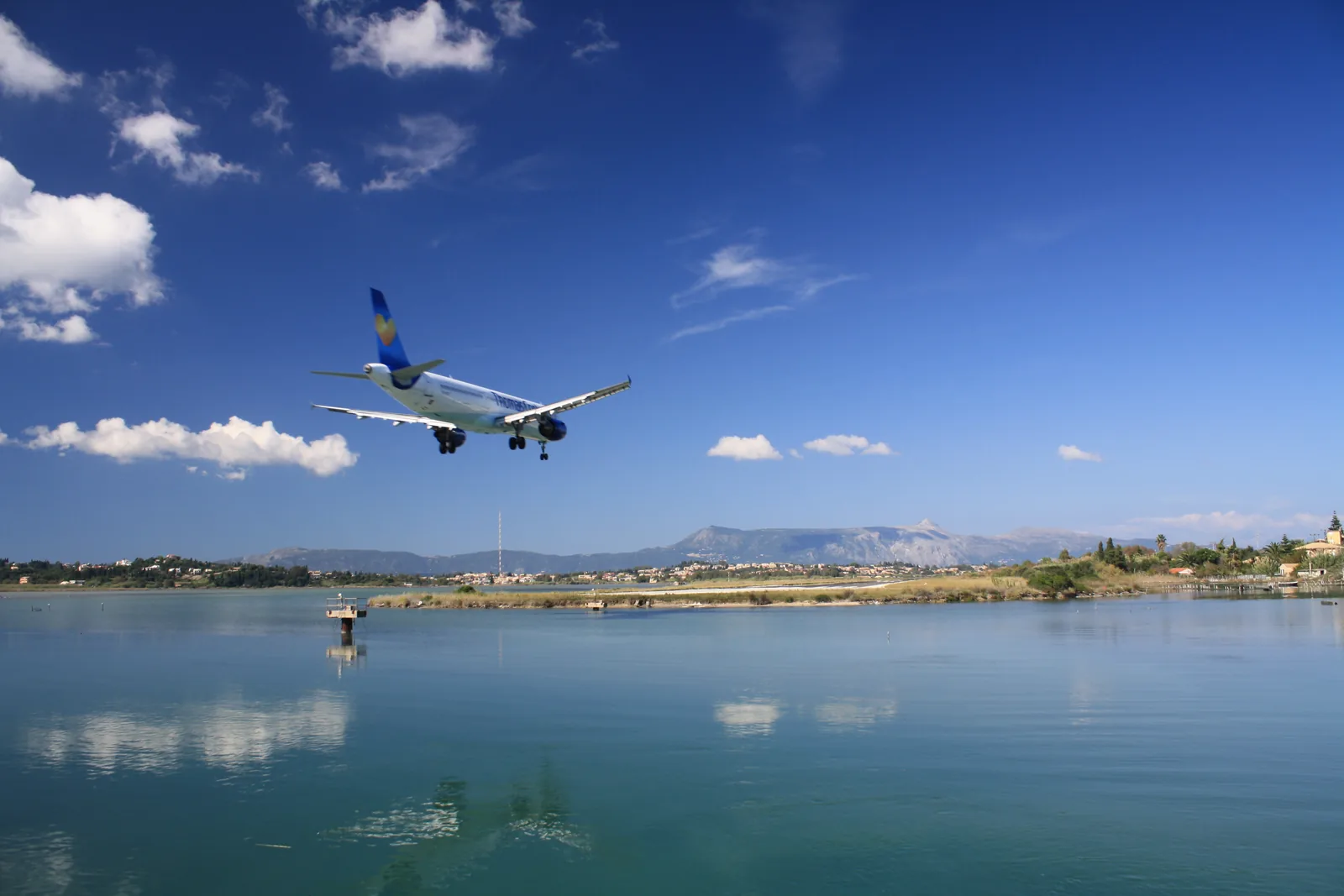 A plane on final approach over the lagoon to Corfu International Airport
